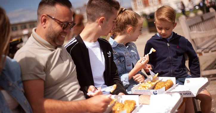 family sat on bench eating fish and chips at Seaham, on the Durham Heritage Coast